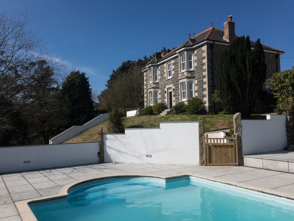 Nanplough Country House standing proud on the hillside above the pool